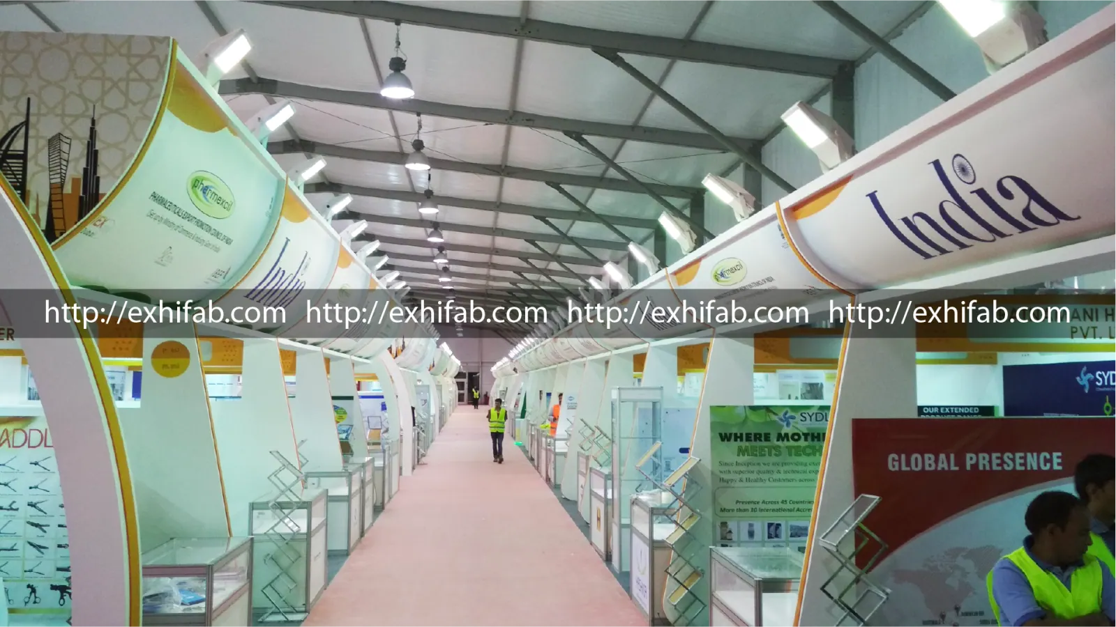 Large India pavilion by Pharmexcil at an international pharma expo with rows of curved co-exhibitor stalls and display cabinets