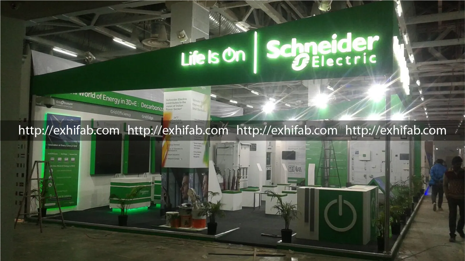 Schneider Electric exhibition stall with illuminated Life Is On branding, green LED accents and multiple product demo zones