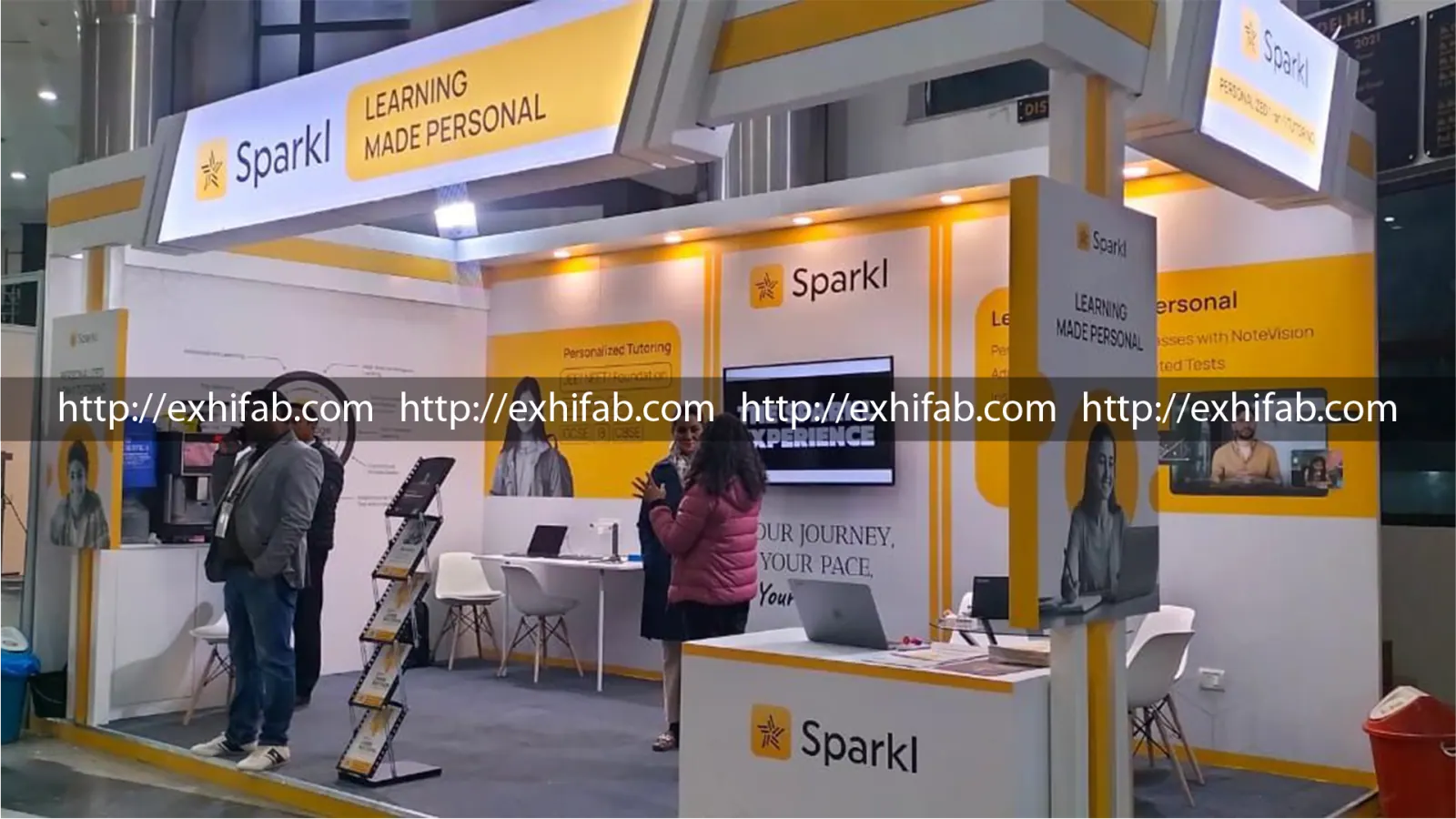 Sparkl EdTech exhibition booth in yellow and white with backlit branding, demo counters and personalised tutoring graphics