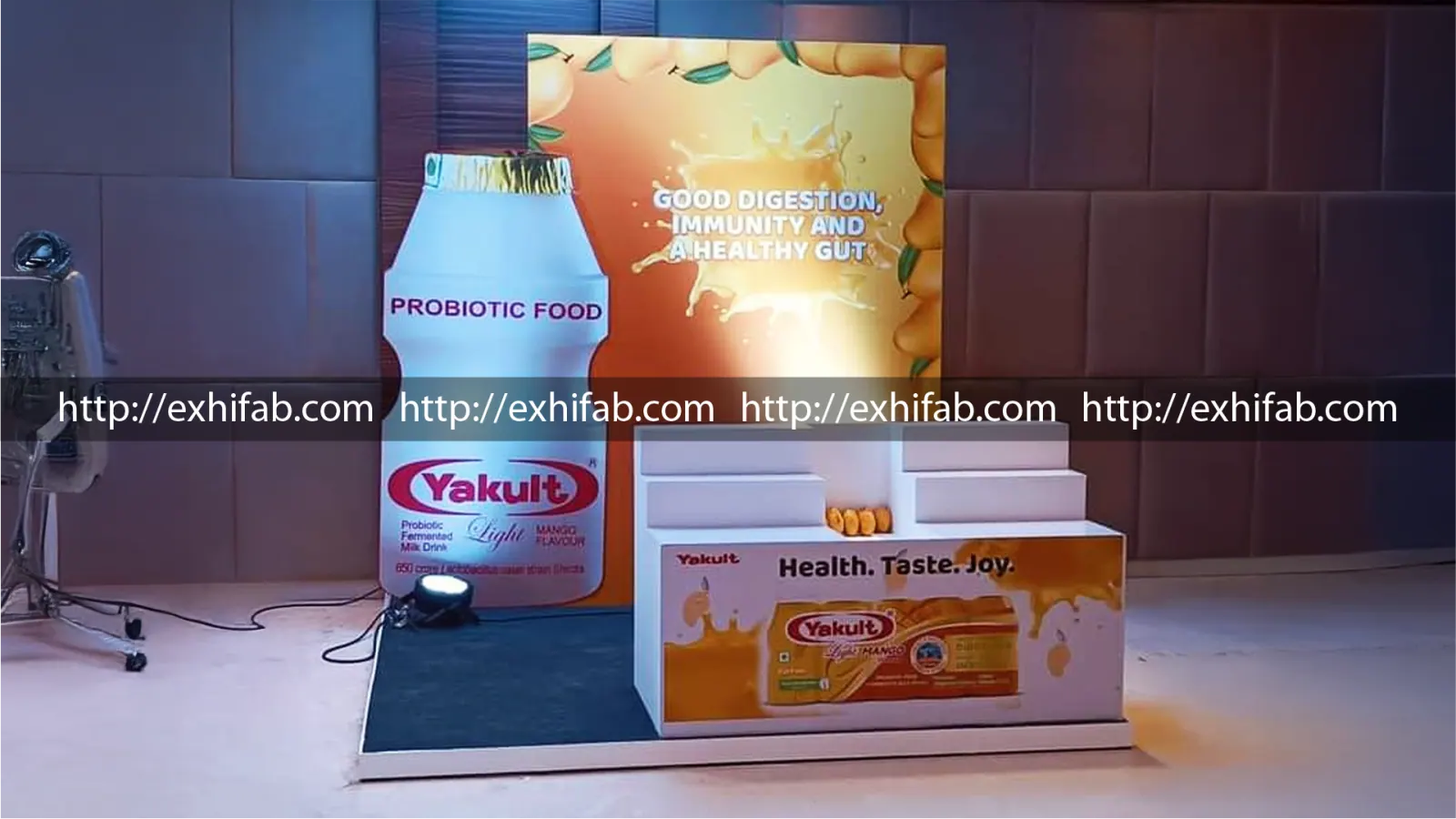 Yakult probiotic drink product launch display with giant bottle replica and mango-flavour campaign backdrop