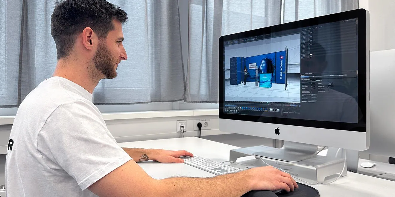 Designer working on a 3D exhibition stall branding render on screen